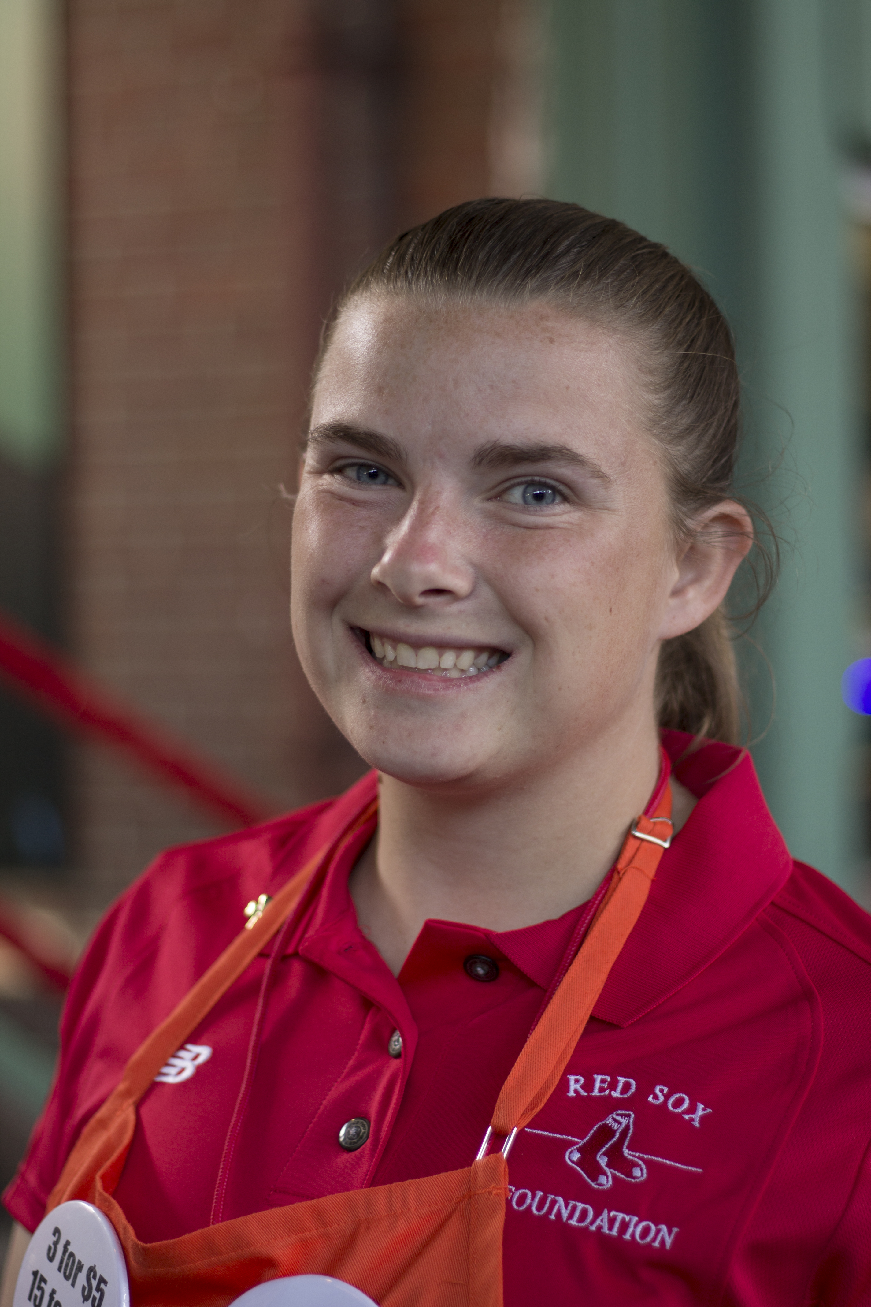 A young white woman wearing a Red Sox Foundation uniform smiles at the camera.