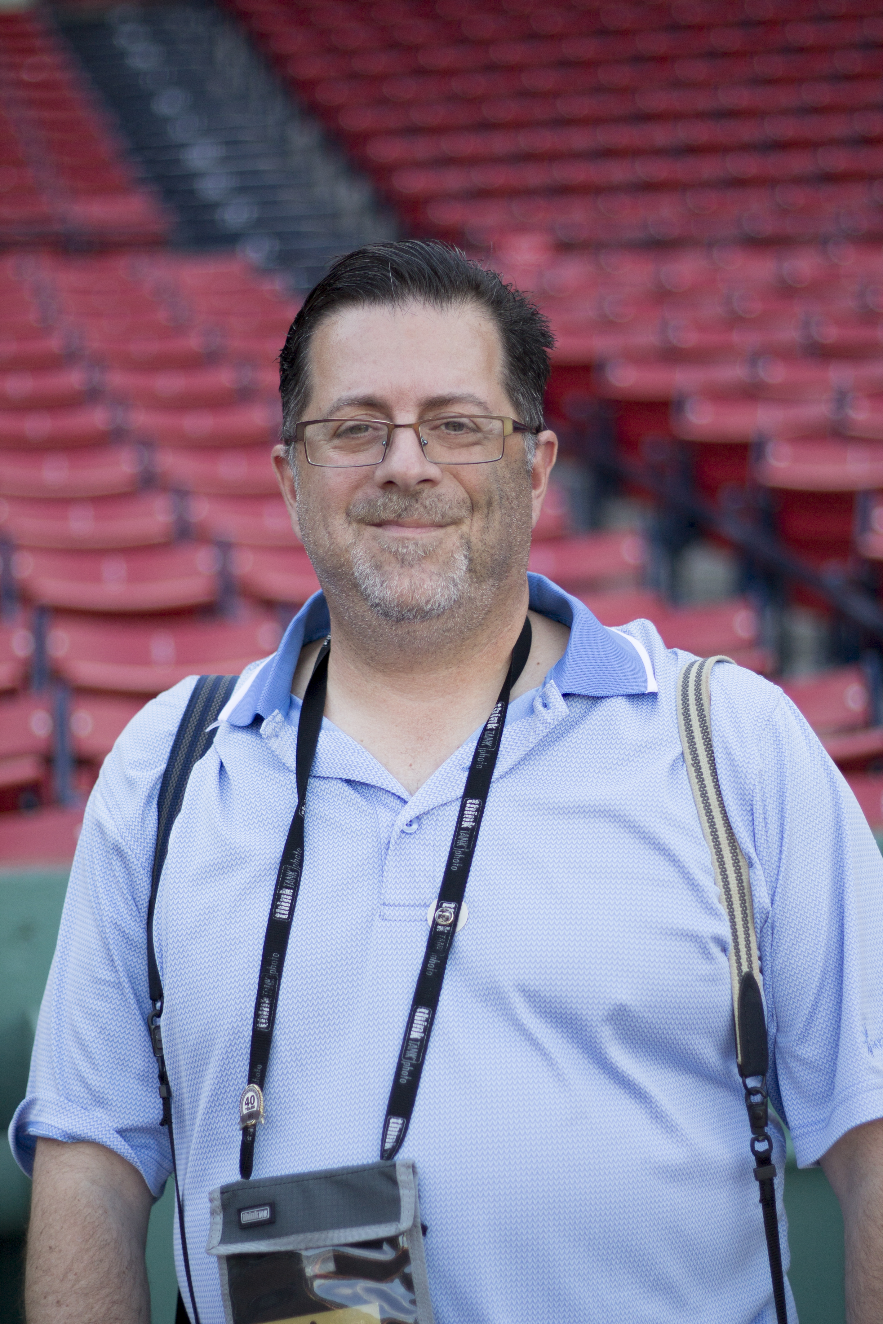 A white man with a blue polo and glasses.